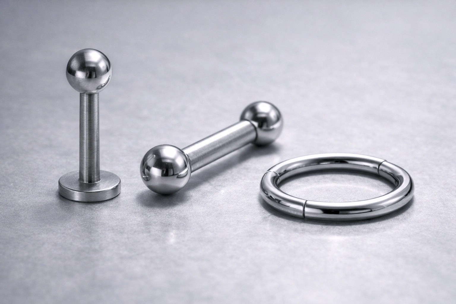 Macro close-up of implant-grade titanium piercing jewelry showing polished and brushed texture