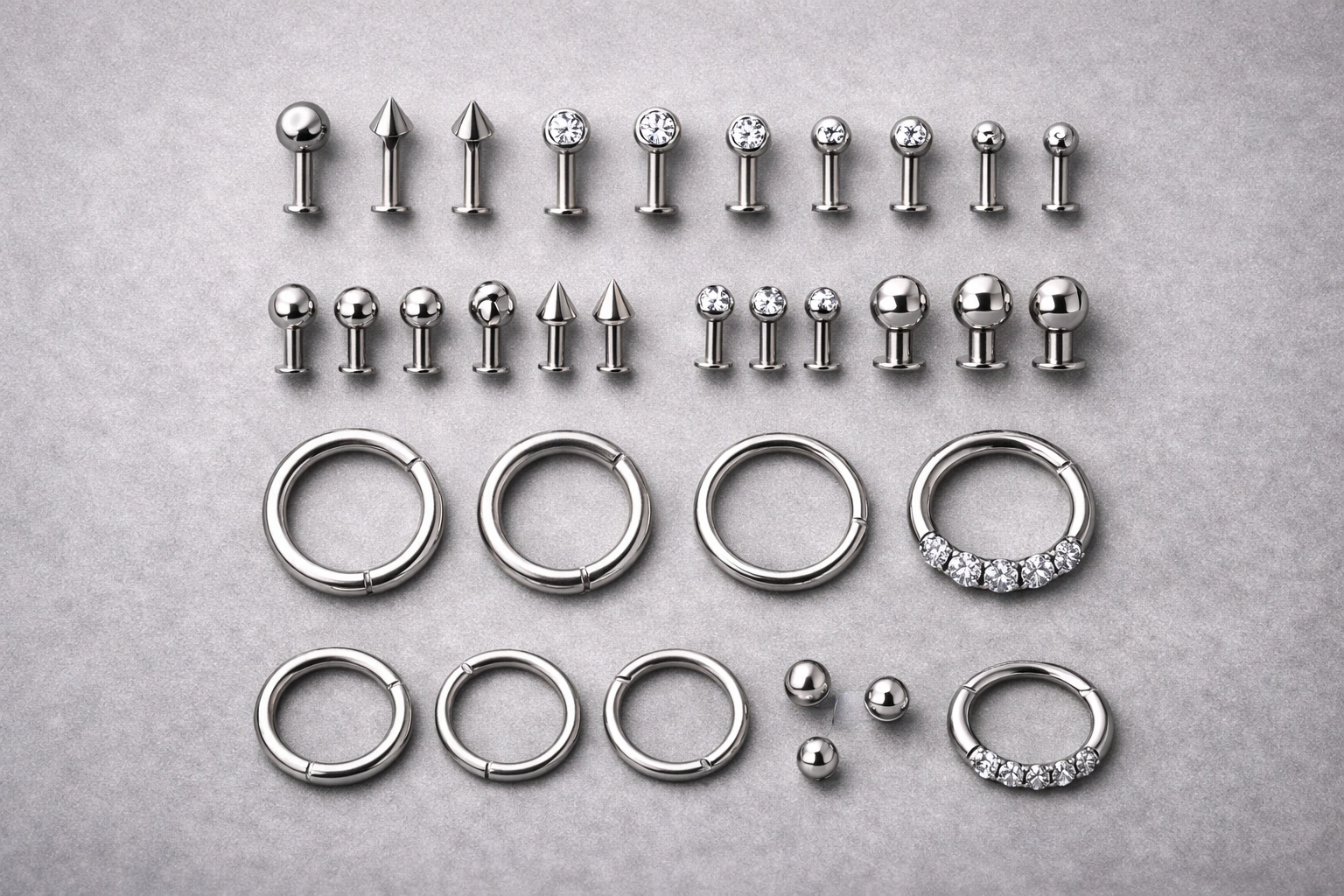 Product family catalog style flat lay of titanium piercing jewelry components